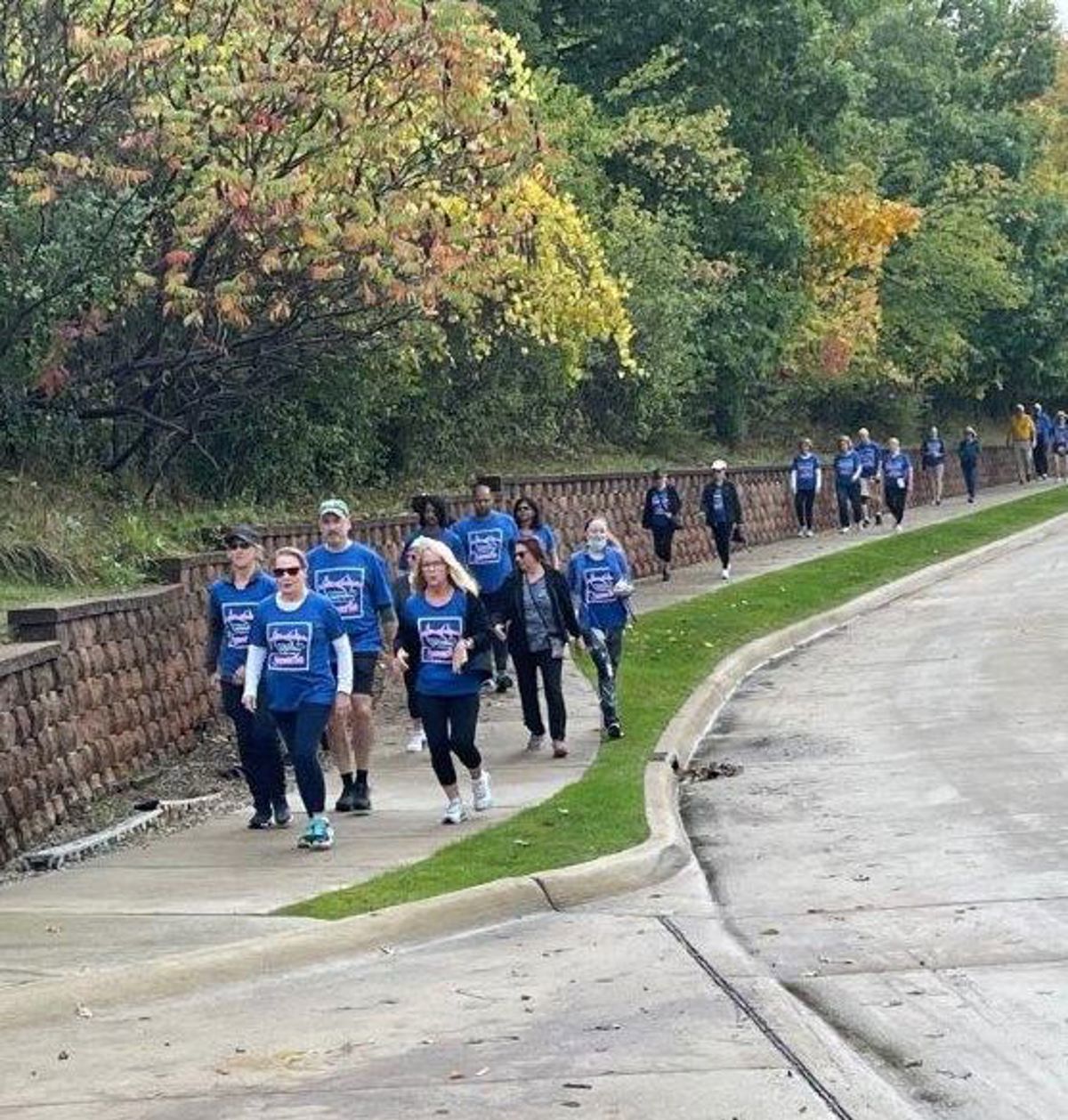 A group of people walking on a sidewalk. 