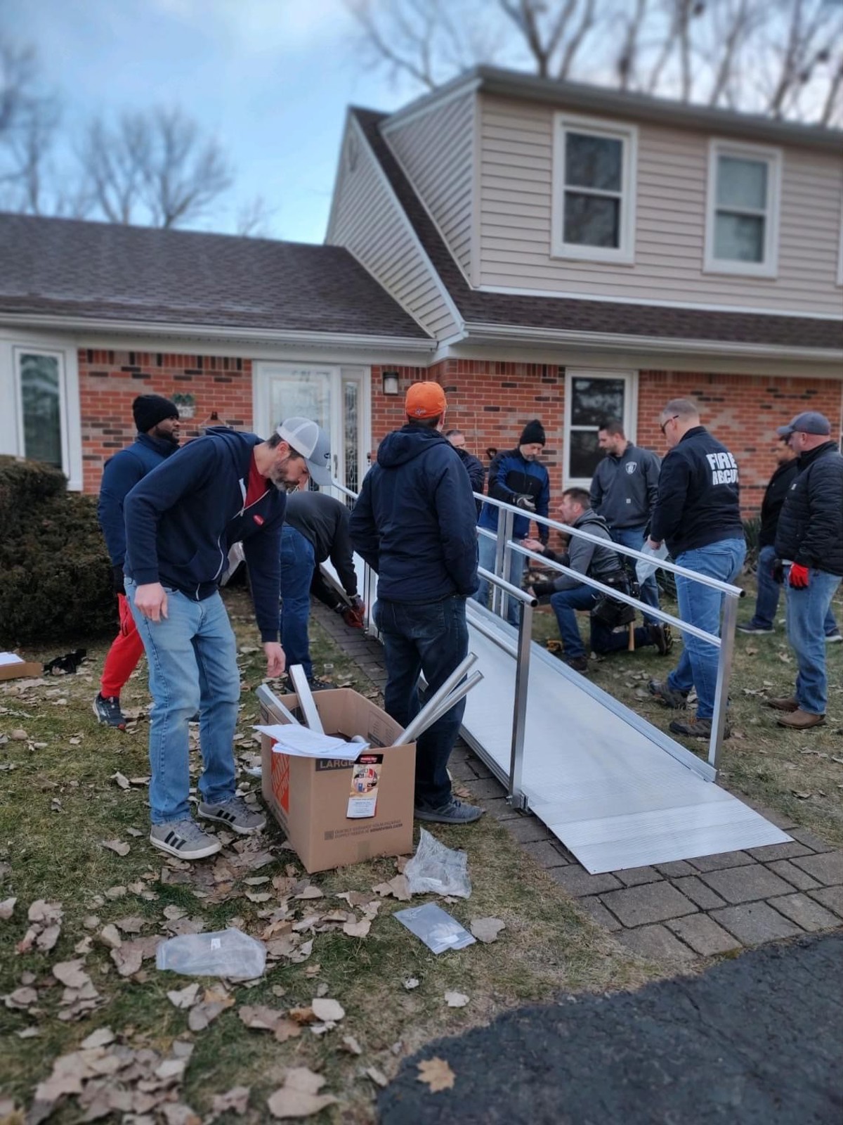 Community members installing a ramp on a front lawn. 