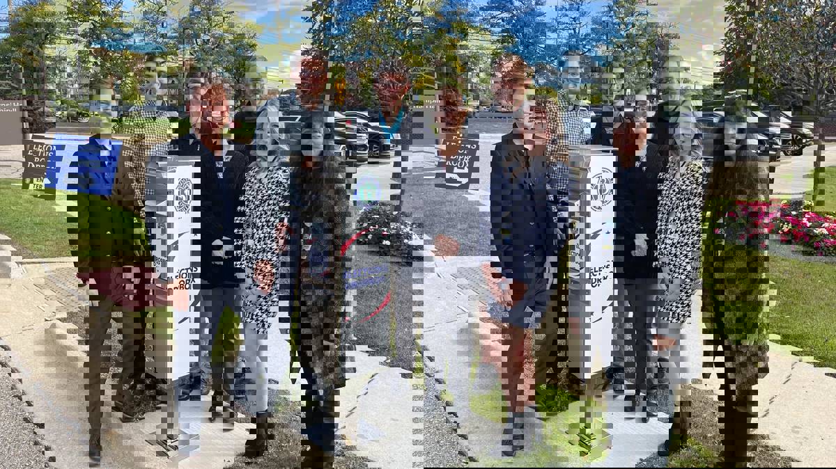 Township employees standing next to an election dropbox. 