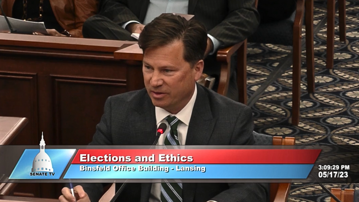A man in a suit sitting in a political building. 