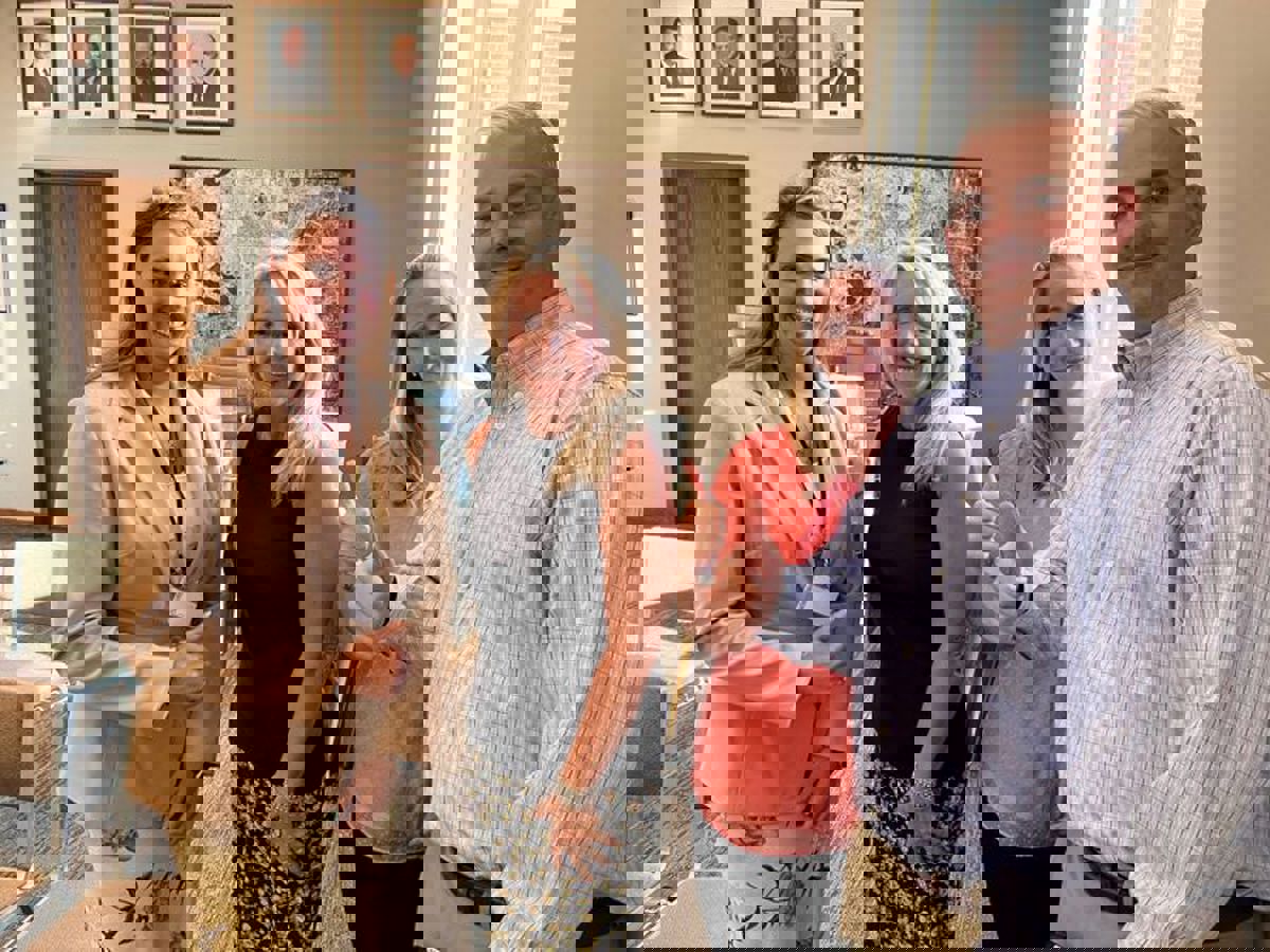 Three woman and a man standing next to each other. 