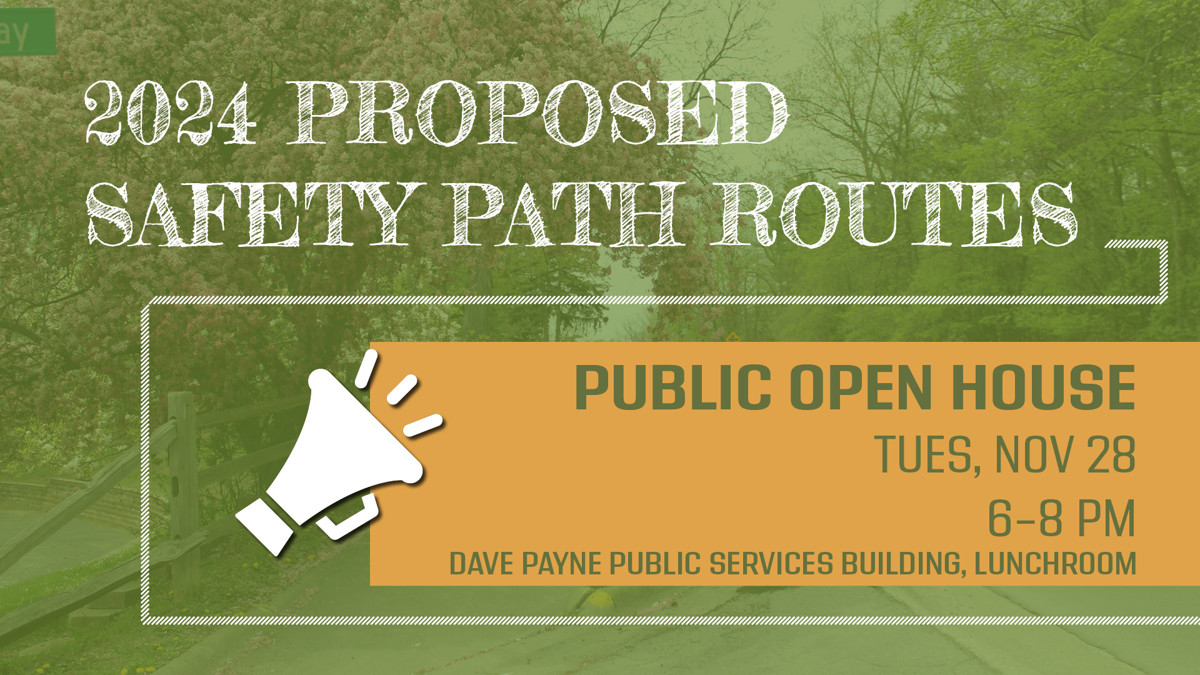 Sidewalk with trees with the words "2024 proposed safety path routes" in front of it. 